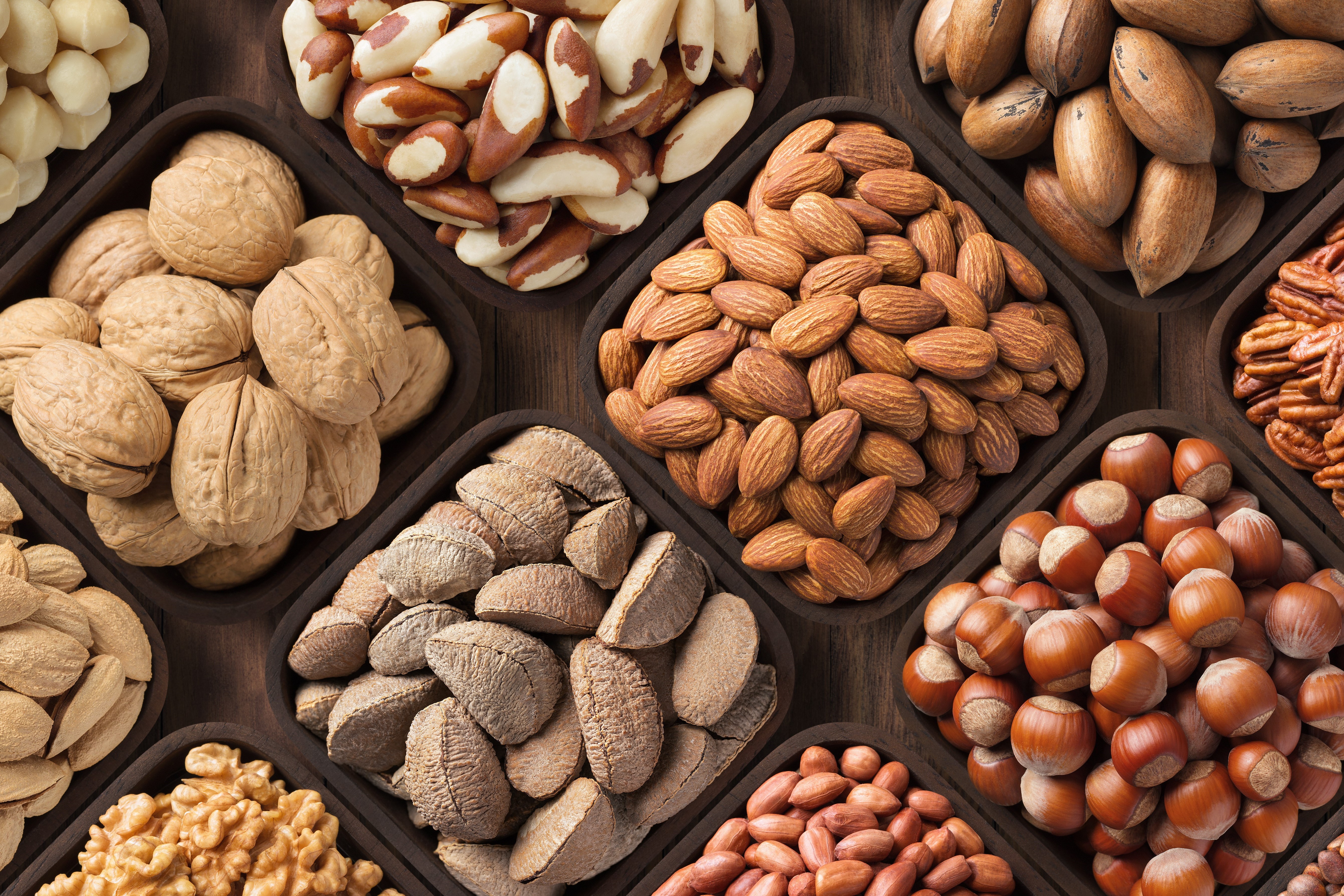 seeds and nuts background, natural food in wooden bowls, top view.